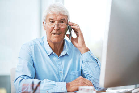Thats interesting.... a handsome senior businessman making a phonecall while working in his office...