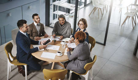 Putting their minds to work. a group of businesspeople having a meeting in an office.