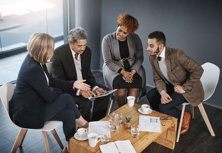 technology helps them with the planning process. a group of businesspeople having a meeting in an office.の写真素材