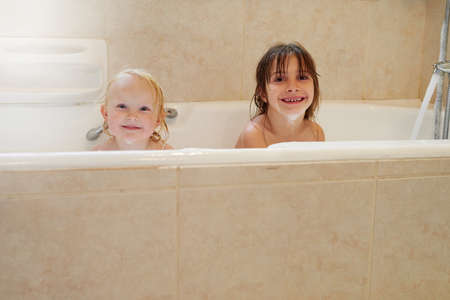 Weve got bubble beards. Portrait of two little girls sitting in a bathtub together.