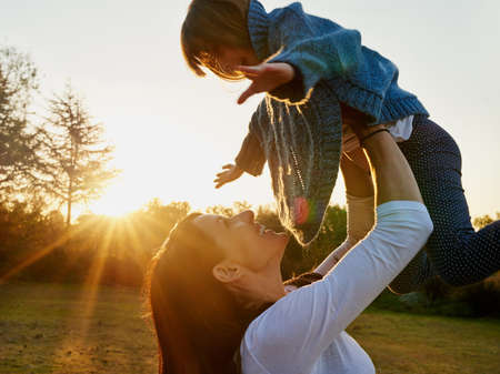 Giving her wings to soar for all her dreams. a mother and daughter enjoying some time outdoors together.の写真素材