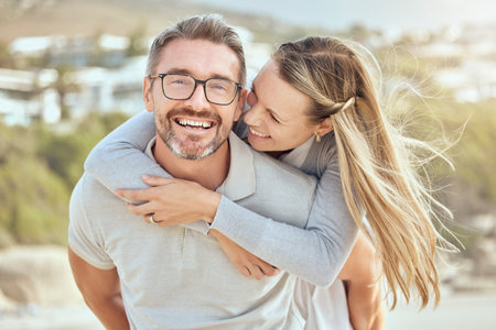 Happy and loving mature caucasian couple enjoying a romantic date at the beach together on a sunny...