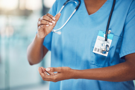 Closeup hands of african american woman nurse standing and holding copyspace in the hospital. Endorsing your lifestyle products. Use this product daily. Health and safety in the field of medicineの写真素材