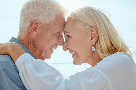 A happy mature caucasian couple enjoying fresh air on vacation at the beach. Smiling retired couple...