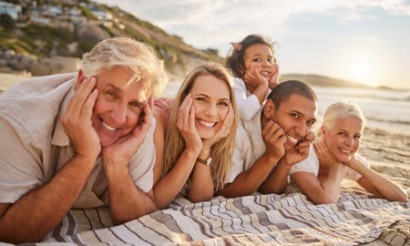 Portrait of a senior caucasian couple at the beach with their children and grandchild. Mixed race...