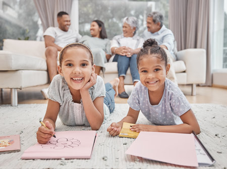Two cute mixed race sibling sisters drawing and colouring in in the living room with their parents and grandparents in the background. Carefree kids playing while mom, dad, granny and grandpa look onの写真素材