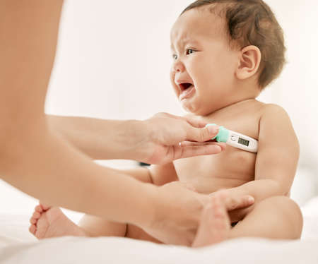 I dont like this, mom. a paediatrician taking a babys temperature with a thermometer.