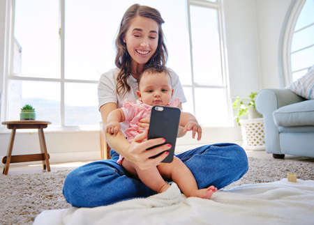 Mommys little girl. a mother taking a selfie with her baby at home.