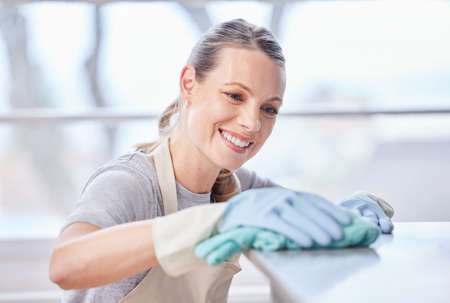 Hygiene is key for health. a young woman wiping a surface with a cloth at home.