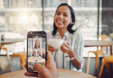 Close up of device screen while taking picture of beautiful young woman holding coffee cup and...