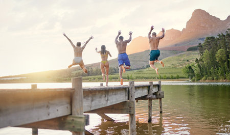 At the lake you have the freedom to enjoy anything. a group of friends having fun at a lake.の写真素材