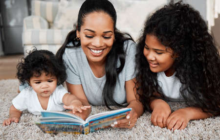 Theyre all Ive ever wanted. a woman reading to her daughters.の写真素材