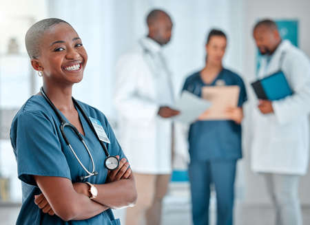 Mature african american female doctor standing with her arms crossed while working at a hospital....