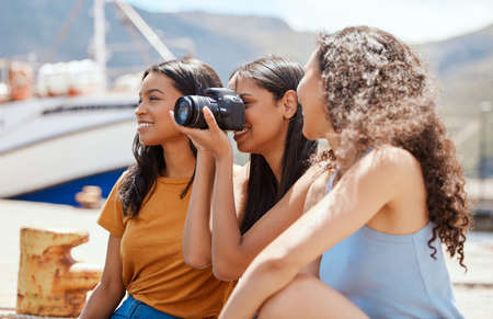 There are so many cool sights to snap out here. a group of young women taking photos on a digital...