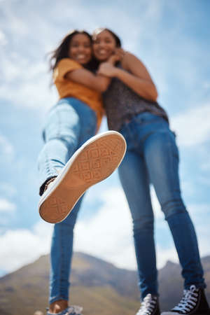 Its better to have a few real friends than many fake ones. Low angle shot of the sole of a shoe of a young woman hanging out with her friend outdoors.の写真素材