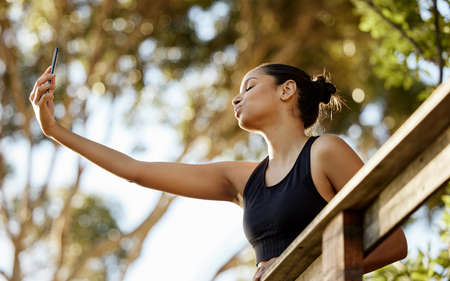 Checking out the view. an attractive young female athlete taking selfies while exercising outdoors.