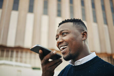 African American businessman using a cellphone in the city. African American businessman using a...