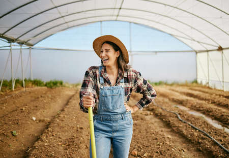 Looking at the culmination of her hard work. a young female farmer working in her greenhouse.の写真素材