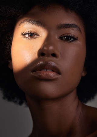 Have soft refreshed skin all day long. a young female posing in a shadow against a grey background.の写真素材