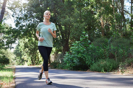 Its never too late to take up running. Low angle shot of a mature woman running outdoors.の写真素材