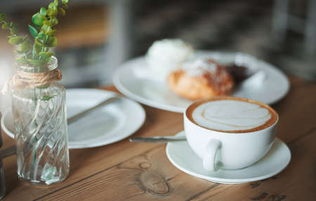 Ready to serve. an empty coffee shop with a cappuccino on a table.の写真素材