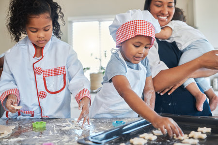 Therere many fun activities that you can do with your children, baking is one of them. a mother holding her baby while baking with her two children.の写真素材