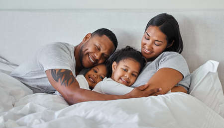 The type of heart that glows in the dark. a beautiful young family talking and bonding in bed together.の写真素材