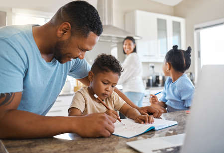 Im so proud. parents helping their children with homework at home.の写真素材