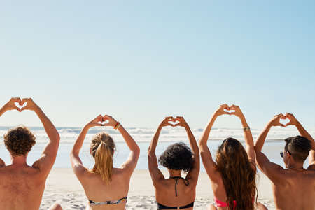 Spread love wherever you go. a group of friends with their hands in the air creating heart shapes.の写真素材
