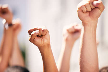 Fighting the dominant power. a group of people with their fists raised at a protest.の写真素材