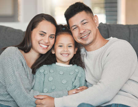 Rejoice with your family in the beautiful land of life. a girl on a couch with her parents at home.