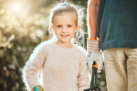 Plant and your family plants with you. an adorable little girl gardening with her grandfather.の写真素材