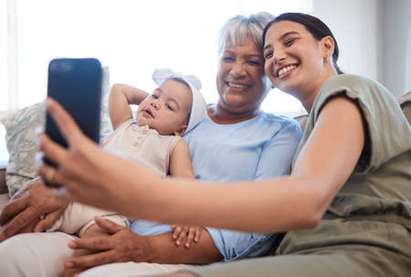 My mums my hero. a mature woman bonding with her daughter and granddaughter on the sofa.の写真素材