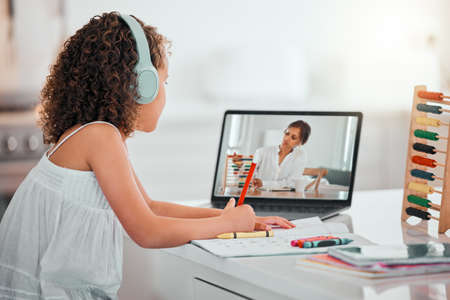 Learning through observation. a little girl in a virtual class from home.
