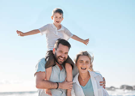Portrait of happy caucasian parents and playful son having fun in sun against blue sky outside....