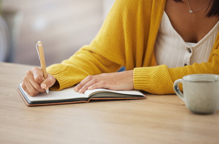 Its all on paper. an unrecognizable businesswoman writing in a notebook at home.