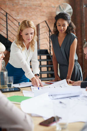 Visualising something bigger. a group of architects working with blueprints in an office.の写真素材