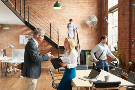 I see you received the report I sent. businesspeople having a discussion in a busy office.の写真素材