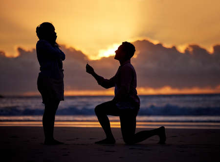 Ive never been this sure about anything. a man proposing to his girlfriend during sunset at the beachの写真素材
