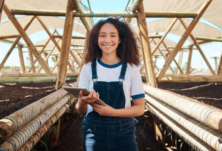 I keep all crop maintenance on digital record. Portrait of a young woman using a digital tablet...