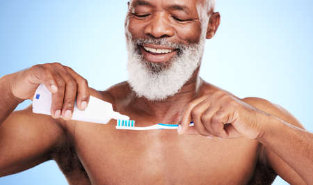 Make sure you brush properly. a handsome mature man posing in studio against a blue background.の写真素材