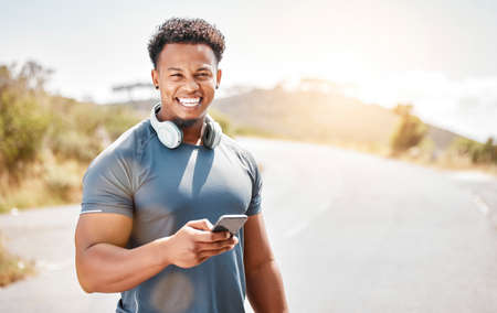 Physical fitness is the basis for health. a young man standing and using his phone outside.