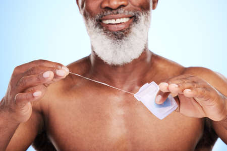 Time to floss. an unrecognizable mature man posing in studio against a blue background.の写真素材