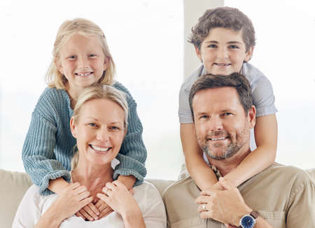 We have our hands full So are our hearts. a beautiful young family bonding on the sofa at home.