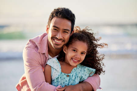 Therere different types of love but nothing is stronger than the love of a parent. a man spending the day at the beach with his adorable daughter.の写真素材