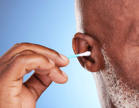 Giving those ears a deep clean. an unrecognizable mature man posing in studio against a blue background.の写真素材