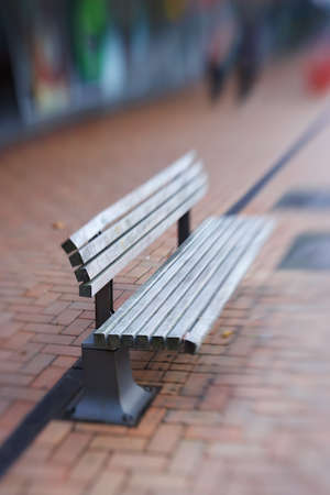 Landscape of empty street bench made of wood. Isolated and weathered outdoor wooden public bench...