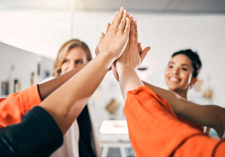 The higher we aim, the greater the success. a group of businesswoman giving each other a high five...