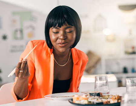 Keeping healthy with a plate of fish. a young woman enjoying a plate of sushi.の写真素材