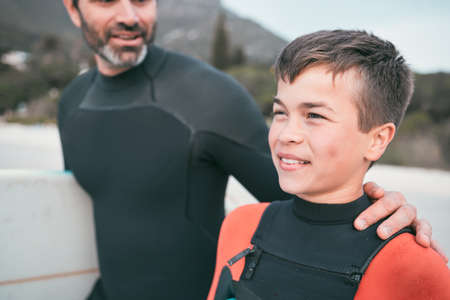 Im looking forward to my first surf session. a young boy out surfing with his father.の写真素材